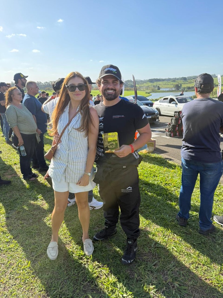 Casal com troféu no paddock do Velocitta